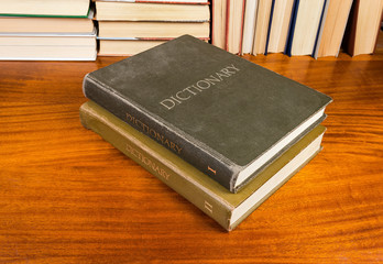 Old hardback dictionary in two volumes on a wooden table
