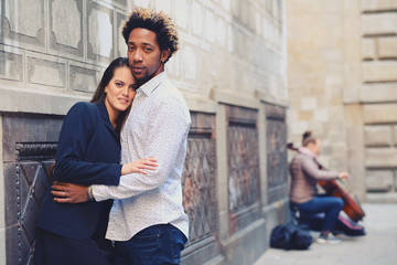 Una pareja feliz y enamorada interracial en las calles de Barcelona pasando un día bonito.
