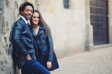 Una pareja feliz y enamorada interracial en las calles de Barcelona pasando un día bonito.