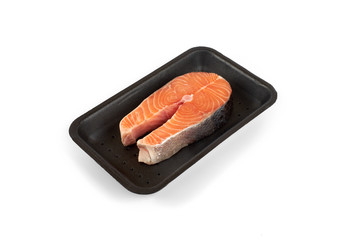 raw salmon steak in the package, isolated on white background.