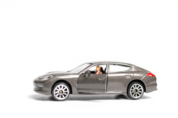Miniature people sitting on car with copy space
