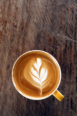 a cup of latte art coffee on wooden background