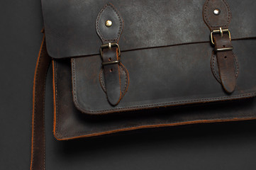 Fashionable concept. Brown leather men's bag on black background top view flat lay with copy space....