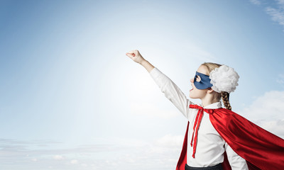 Girl power concept with cute kid guardian against cloudscape bac