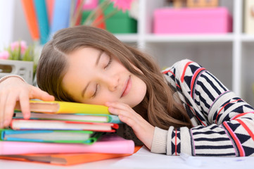 Close up portrait of cute schoolgirl sleeping on table