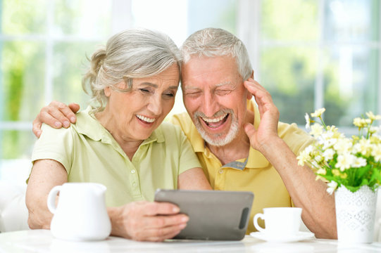 Portrait of beautiful senior couple using tablet