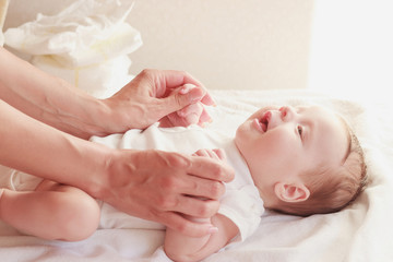 Baby and hands of mother, indoors, blurred background
