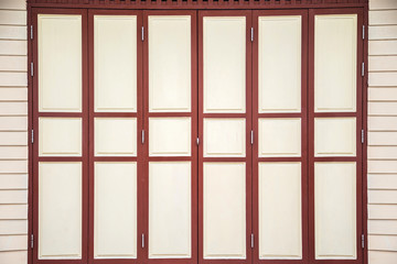 A patterned vintage beige and red wooden door with beige wall
