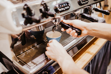 Prepares espresso in his coffee shop with hand. close up