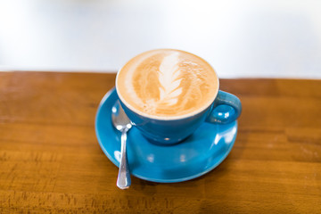 Cup of cappuccino, cup of coffee on brown wooden table in cafe shop