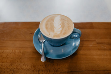 Cup of cappuccino, cup of coffee on brown wooden table in cafe shop