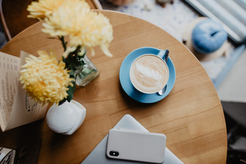 Minimalistic flat lay composition. Laptop computer, cell phone gadget, cup of coffee on textured wooden desk table background. Workspace top view, copy space