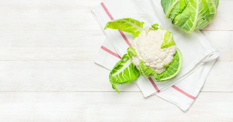 Fresh raw cauliflower, kitchen towel on rustic white wooden background top view flat lay copy space. Cooking, healthy wholesome food, vegetable, diet concept.