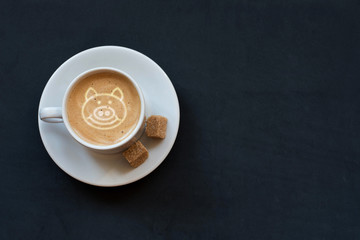Cup of coffee with milk, cane sugar and symbol of 2019 pig on milk foam. Top view. With Copy space