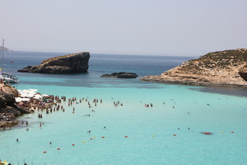 Fototapeta na wymiar Blue Lagoon Malta estate con turisti e bagnanti in spiaggia