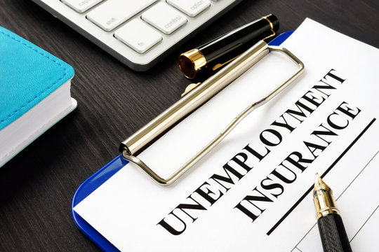 Unemployment Insurance Form And Clipboard On A Desk.