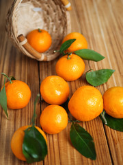 Ripe tangerines on a wooden table in a basket