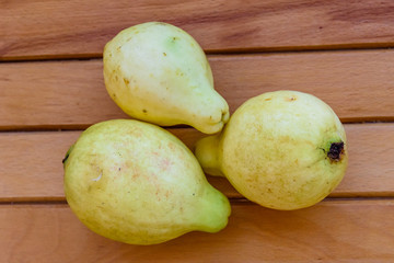 Ripe yellow guava fruits on wooden table