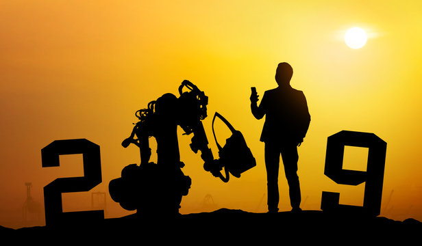 2019 years of robot assistant technology , industry 4.0 , artificial intelligence trend concept. Silhouette of business man control automation robo advisor arm with sunrise logistic bakckground.