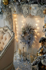 Three-horn candlestick, garland. White and silver decor. The new year atmosphere. Christmas decoration at home.
