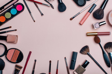 set of beauty cosmetics for female face and eye makeup on pink background