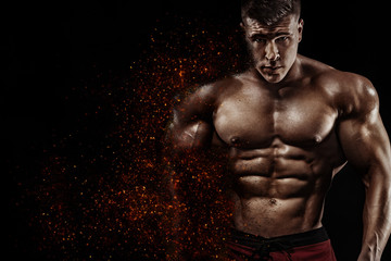 Brutal strong muscular bodybuilder athlete man pumping up muscles on black background. Workout bodybuilding concept. Copy space for sport nutrition ads. - obrazy, fototapety, plakaty