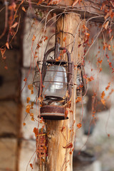una vecchia lampada appesa fuori di una baita di montagna - 240355093