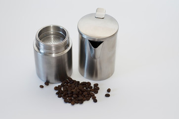 aluminum guiser coffee maker and coffee beans on light background