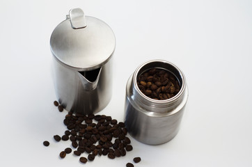 aluminum guiser coffee maker and coffee beans on light background