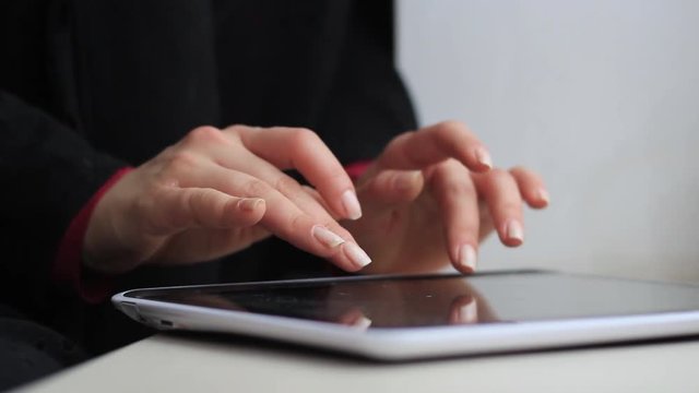 Women's hands work with a tablet computer