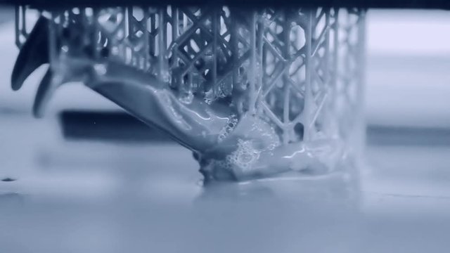 Stereolithography DPL, SLA 3d printer creating shape by UV polymerization. close-up. Progressive modern additive technology 3D printing. Multicam group video montage