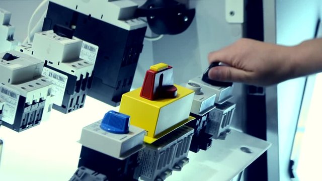 Person clicks pushing on the control panel buttons and pressing the lever close-up. Person tilts the lever to turn it on oa turn off. Control buttons panel close-up.