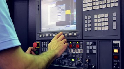 Man working on the control panel works with an industrial machine at the factory close-up. Industrial machinery, production aggregation and equipment mechanical automaton. Heavy machinery - Powered by Adobe