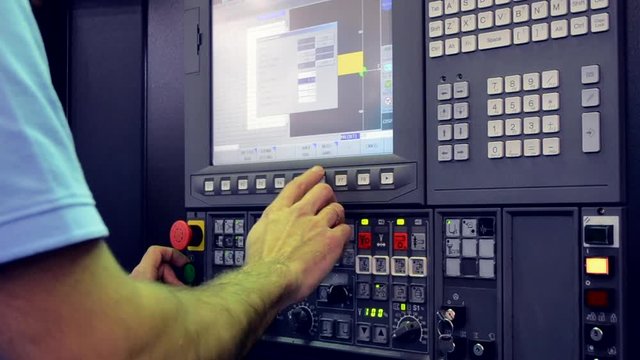 Man working on the control panel works with an industrial machine at the factory close-up. Industrial machinery, production aggregation and equipment mechanical automaton. Heavy machinery