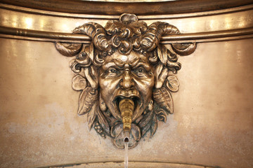 Antique street bronze drinking water fountain myth half goat half human face sculpture in Church of...
