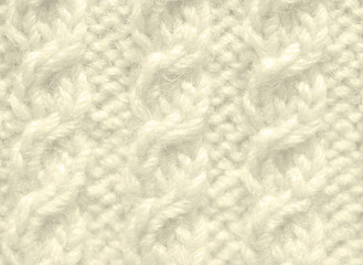The texture of the knitted fabric is beige. Background of woolen threads.