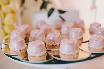 Delicious desserts and sweets on table party at wedding reception. White and pink stylish candy bar. Christmas and New Year feast. Celebrations and party concept