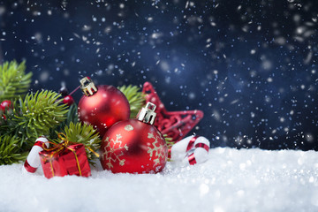 Christmas balls with tree and decorations on snow