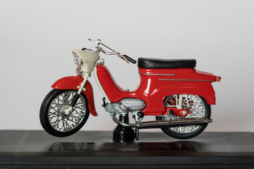 Fototapeta premium Veteran red plastic motorbike on a stand.