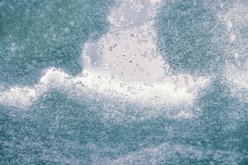 Texture of snow and ice on the glass, winter background. Wallpaper for installation.