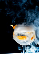 Glass of gin and tonics with ice and smoke