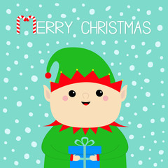 Merry Christmas. Santa Claus Elf face holding gift box. Green hat. Happy New Year. Cute cartoon funny kawaii baby character. Greeting card. Flat design Blue snow background.
