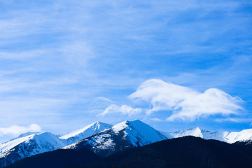 Mountain snow peak, beautiful natural winter backdrop. Ice top of the hill, blue sky background. Alpine landscape.