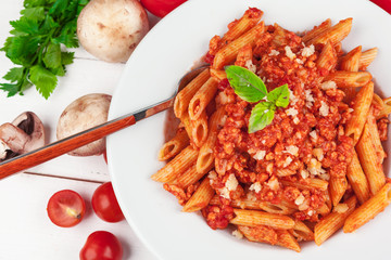 Pasta with meat, tomato sauce and vegetables on the table