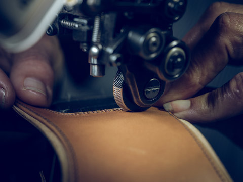 Crop hands attaching sole on shoes