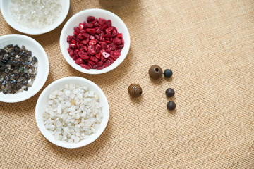 Top view of table with plates with gemstone beads or natural mineral stone beads and other beads are prepared for beading