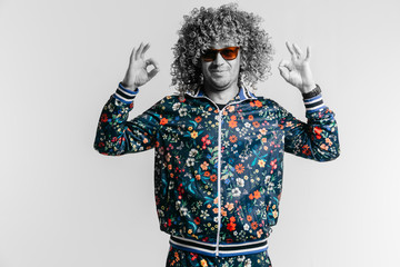 Adult positive smiling funky man with afro curly hair style in suglasses, multicolored clothes...