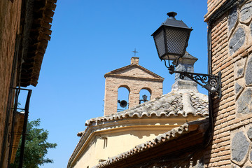 Fototapeta na wymiar Street lamp and steeple in Toledo on midday