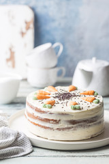 Healthy homemade carrot cake with cream cheese frosting on white wooden table