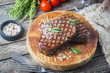 Grilled marbled meat steak Filet Mignon with seasonings. Juicy beef steak on cutting board.